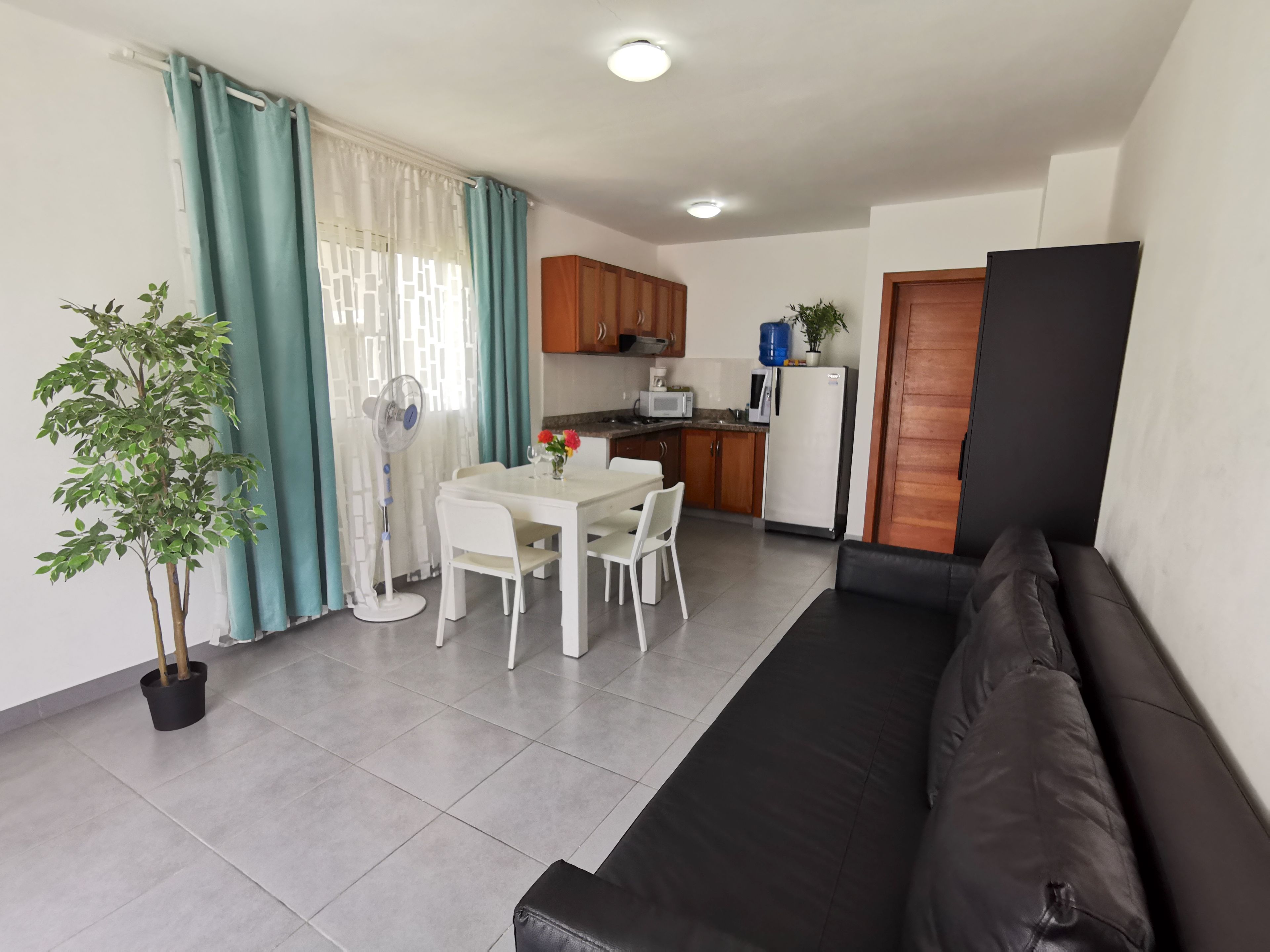 Um espaço compacto com cozinha compacta, área de refeições e espaço de estar.
