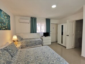 A bedroom with two beds, a TV, a desk, and a wardrobe. - TROPICANA FAMILY CLUB playa LOS CORALES (La Altagracia Province)