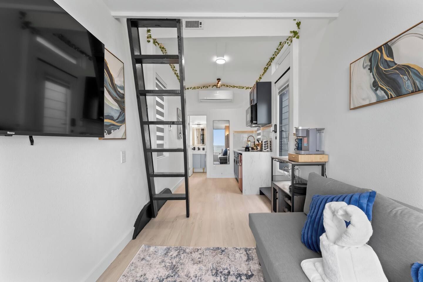 Een moderne woonkamer met een bank, een televisie en een ladder.