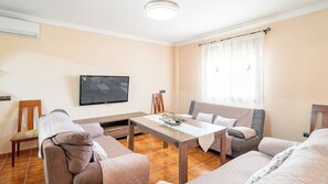 A living room with a sofa, armchair, and a table with a tray. - Casa Maria Caminito del Rey Valle de Abdalajís by Ruralidays (Province of Málaga)
