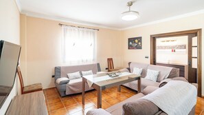 A living room with a sofa, a coffee table, and a television. - Casa Maria Caminito del Rey Valle de Abdalajís by Ruralidays (Province of Málaga)