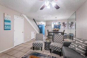 A living room with a staircase, a dining area, and a kitchen. - Near Tampa, St. Pete & Top Beaches + Pet-Friendly! (Largo)