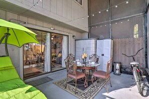 A patio with a dining table, chairs, and a green umbrella. - Near Tampa, St. Pete & Top Beaches + Pet-Friendly! (Largo)