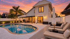 A modern house with a swimming pool, outdoor seating, and a patio area. - Navigate Stays Delray Beach, FL, Pool - Near Beach (Delray Beach)