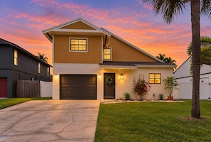A two-story house with a garage, a front porch, and a well-maintained lawn.