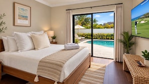 A bedroom with a large bed, a TV, a pool view, and a framed picture on the wall. - Navigate Stays Delray Beach, FL, Pool - Near Beach (Delray Beach)