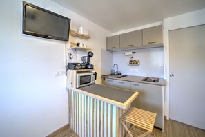 A compact kitchenette with a microwave, coffee maker, and a small sink.