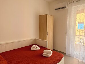 A hotel room with a bed, a wardrobe, and a window with a view of buildings. - WALK37 Syracuse - Between the Greek Theater and Ortigia (Siracusa)