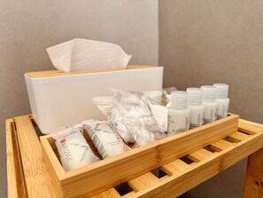 A wooden tray with toiletries including a box, bottles, and tissue packs. - WALK37 Syracuse - Between the Greek Theater and Ortigia (Siracusa)