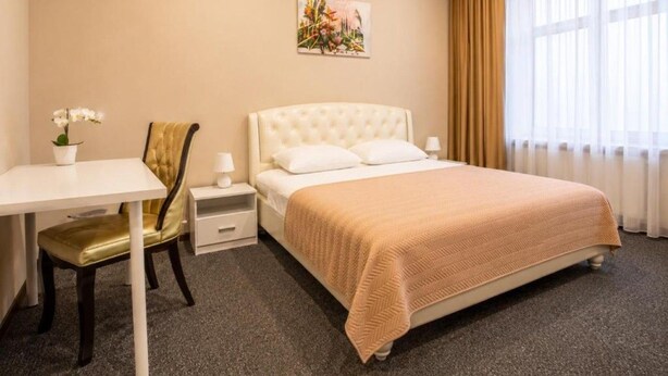 Ein Hotelzimmer mit einem Bett, einem Schreibtisch, einem Sessel und einem Nachttisch.