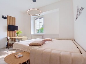 Een moderne slaapkamer met een bed, nachtkastje en een raam.