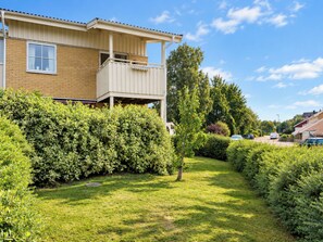 A residential building with a balcony, surrounded by well-maintained hedges and a grassy lawn. - Cityhuset by Interhome (Falkenberg)