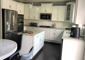 A modern kitchen with white cabinetry, stainless steel appliances, and a granite countertop. - Great Family place to stay out of the city (High Point)