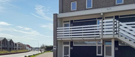 A modern building with a balcony and a staircase.