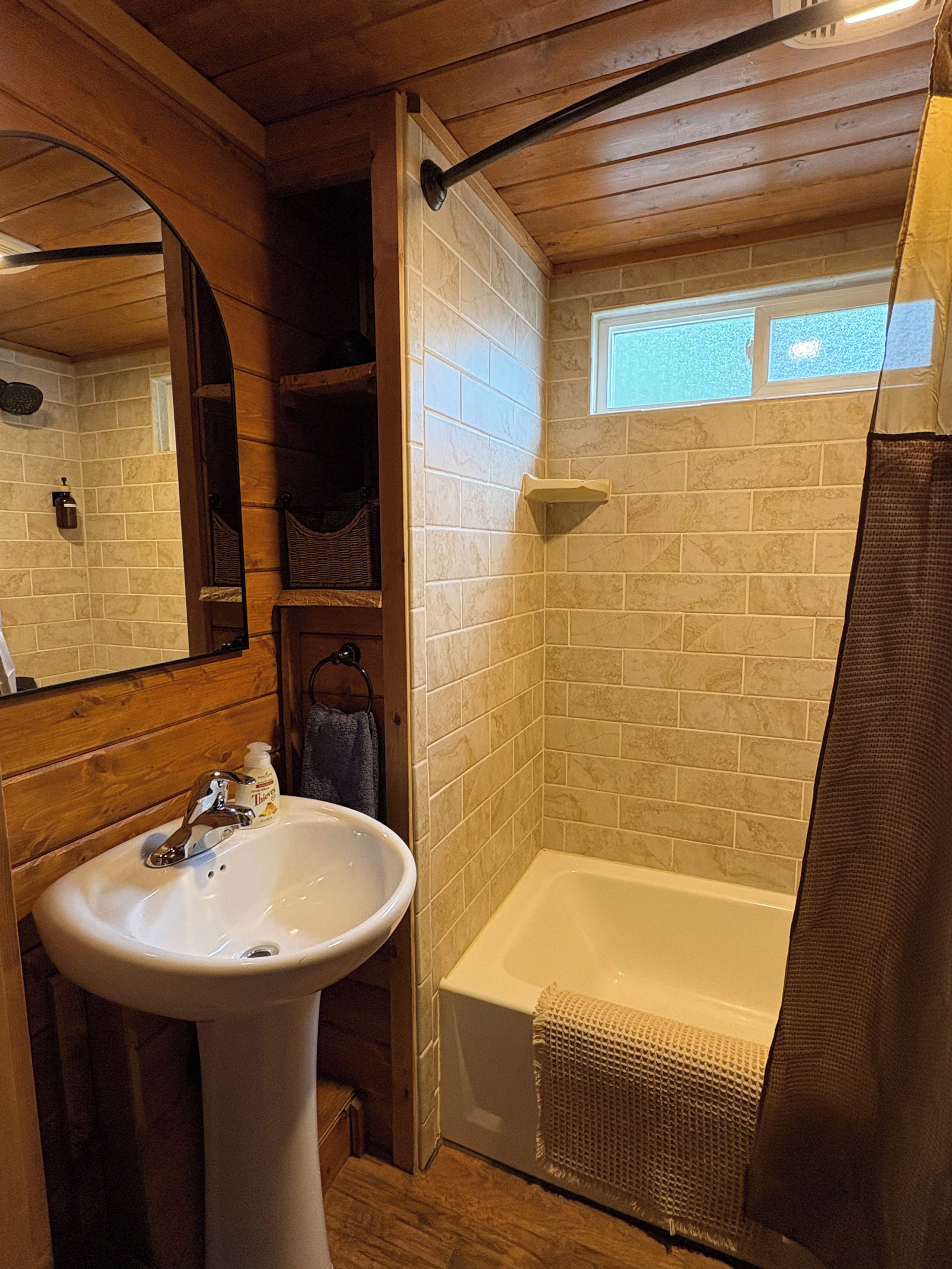 Ein Badezimmer mit einem weißen Waschbecken, einer Badewanne und einer Duschvorhang.