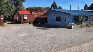 A small building with a red roof and a blue building with a door and windows. - Little Strawberry Suites, Tiny Home Downtown Prairie City (Prairie City)