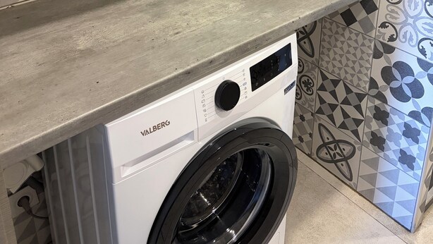 A laundry area with a washing machine, a shelf, and patterned tiles. - Vrbo Property (Sausset-les-Pins)