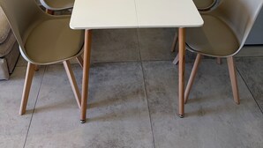 A minimalist room with a white table and four beige chairs. - Vrbo Property (Sausset-les-Pins)