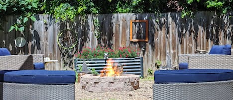A patio with wicker furniture and a fire pit.
