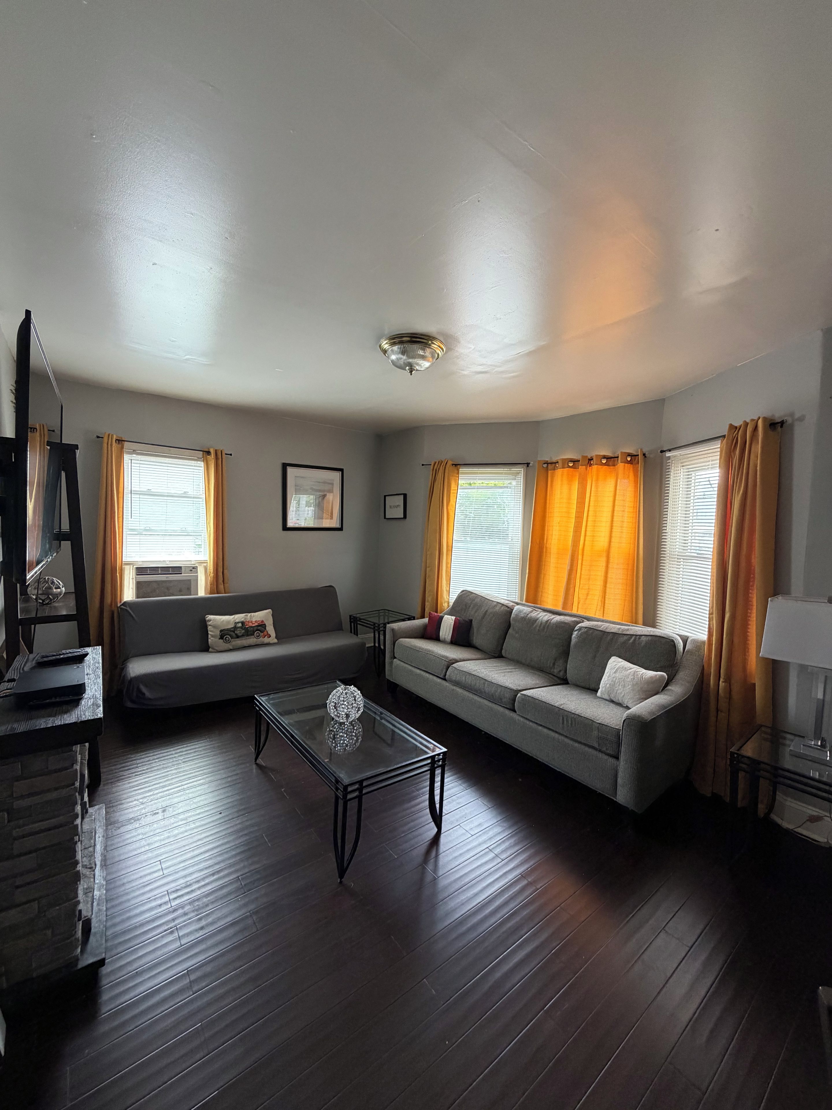 A living room with a sofa, a coffee table, and a television.