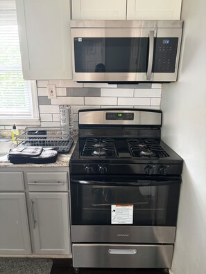 A kitchen with a stainless steel stove, oven, and microwave. - Modern, Two Family Home in Orange (City of Orange)