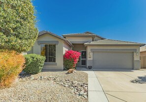 A residential house with a garage, a driveway, and a landscaped front yard.