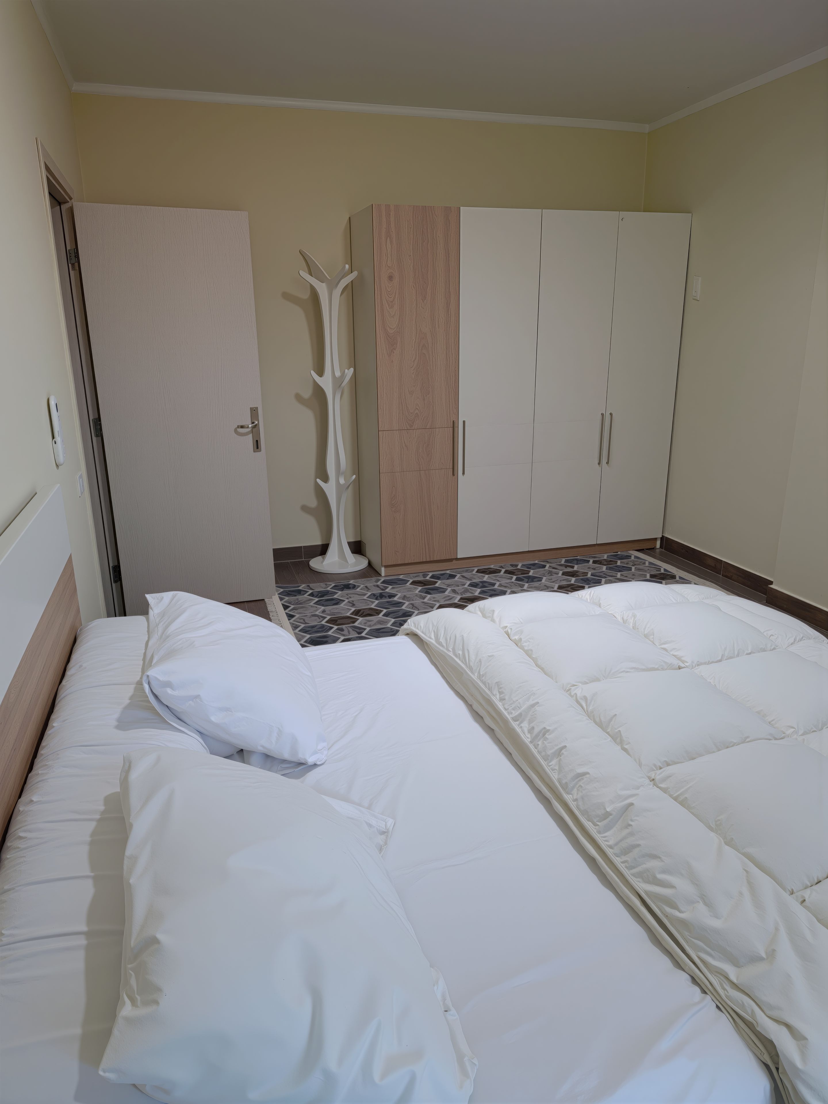 Ein Schlafzimmer mit einem Bett, einem Kleiderschrank und einer Tür.