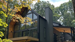 Et moderne hus med to etager, en balkon og en terrasse.