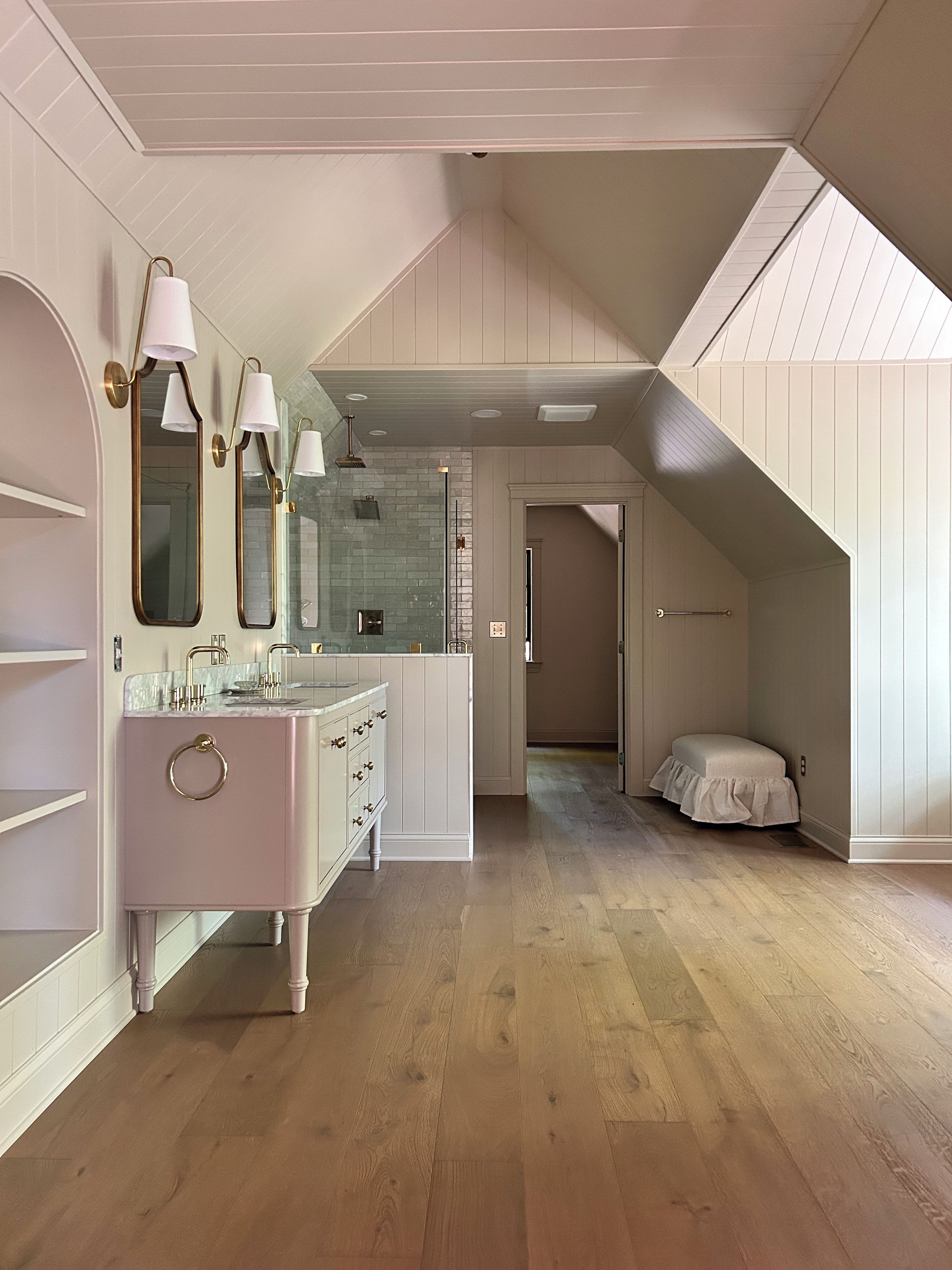 A modern bathroom with a vanity, mirrors, and a shower area.
