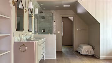 A modern bathroom with a vanity, mirrors, and a shower area.