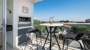 A balcony with a grill, two chairs, and a table. - Fully Equipped Apt, Pool & Workspace, City Views (Asunción)