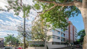 A multi-story building with a modern architectural design, a street with parked cars, and a pedestrian crossing. - Fully Equipped Apt, Pool & Workspace, City Views (Asunción)