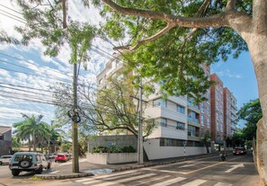 A multi-story building with a modern architectural design, a street with parked cars, and a pedestrian crossing. - Fully Equipped Apt, Pool & Workspace, City Views (Asunción)