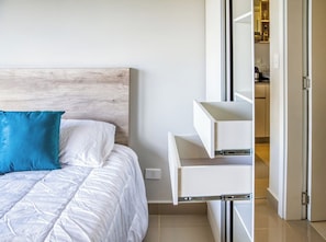 Ein Schlafzimmer mit einem Bett, einem Nachttisch und einem Einbauschrank.