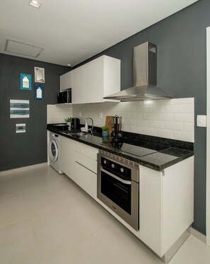 A modern kitchen with a built-in oven, microwave, and stainless steel range hood. - Business Stay with Fast Wi-Fi, Pool and Workspace (Asunción)