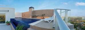 A rooftop swimming pool with a glass balustrade, lounge chairs, and a city view. - Business Stay with Fast Wi-Fi, Pool and Workspace (Asunción)