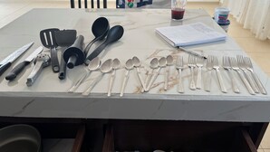 Een tafel met verschillende keukengerei en een notitieboekje.