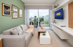Ein modernes Wohnzimmer mit einer Couch, einem Couchtisch und einem Fernseher an der Wand.