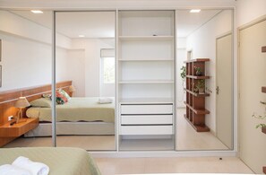 Ein Schlafzimmer mit einem Bett, einem Nachttisch und einem Schrank mit Einlegeböden.