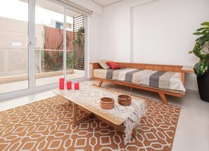 Ein modernes Wohnzimmer mit einer Couch, einem Couchtisch und einem großen Fenster.