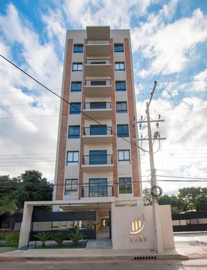 A multi-story building with a modern architectural design, featuring a garage entrance and a sign with the name 'ZUBA'. - Modern 1BR | Rooftop Pool, Coworking & City Views (Fernando de la Mora)