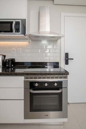 A modern kitchen with a built-in microwave, toaster, and stainless steel oven. - Stunning Hub with City Views, Pool and Balcony (Asunción)
