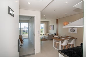 A modern apartment with a dining area, kitchen, and a living space with a sofa and a coffee table. - Stunning Hub with City Views, Pool and Balcony (Asunción)