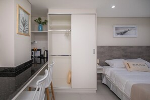 Ein modernes Schlafzimmer mit einem Bett, einem Nachttisch, einer Kommode und einem Kleiderschrank.
