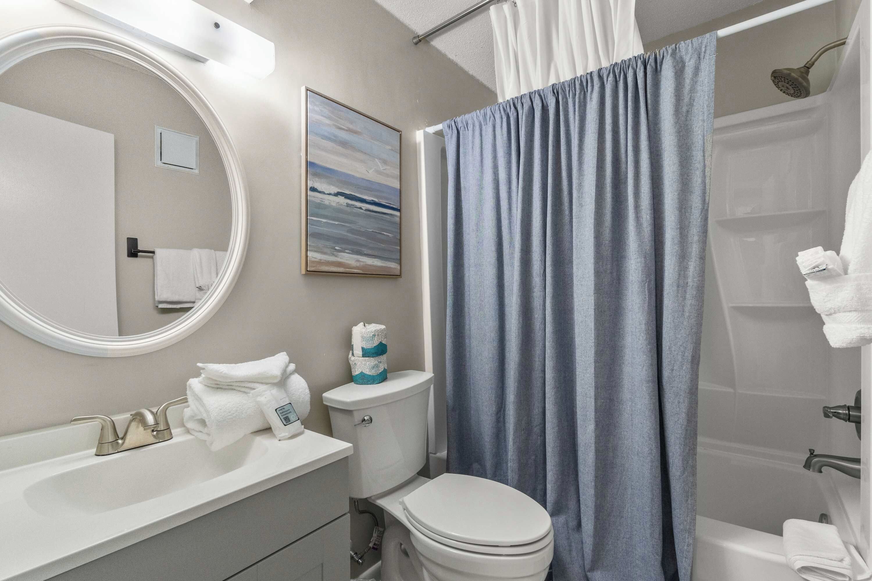 Een badkamer met toilet, wastafel en douche.