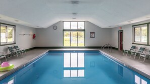 Ein Pool mit Blick ins Freie, eine Uhr an der Wand und ein Warnschild.