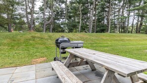 Eine Außenpatio mit Grill und Picknicktisch.