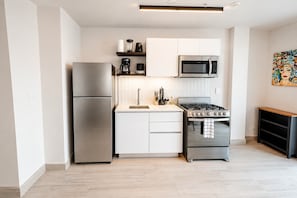 A modern kitchen with a refrigerator, microwave, stove, and sink. - Apartment with Balcony (Panamá)
