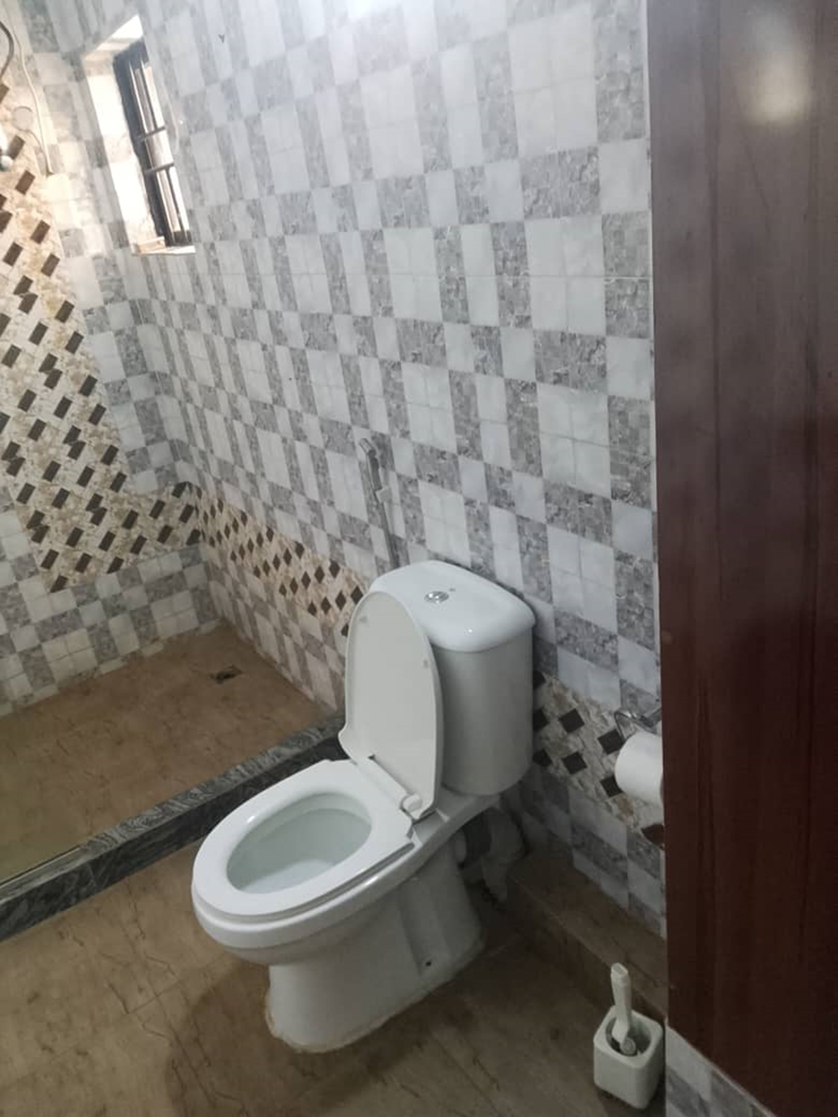 Un baño con inodoro, bidé y un dispensador de papel higiénico.