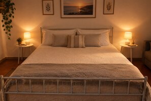 A neatly made bed with a headboard, two bedside tables with lamps, and framed artwork on the wall. - Beach house, 50 meters from the beach.  Your Perfect Spot in Palermo (Palermo)